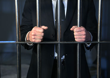 Lawyer behind bars symbolizing confidentiality breaches in sexual harassment cases.