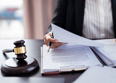 Lawyer reviewing documents related to sexual harassment cases.